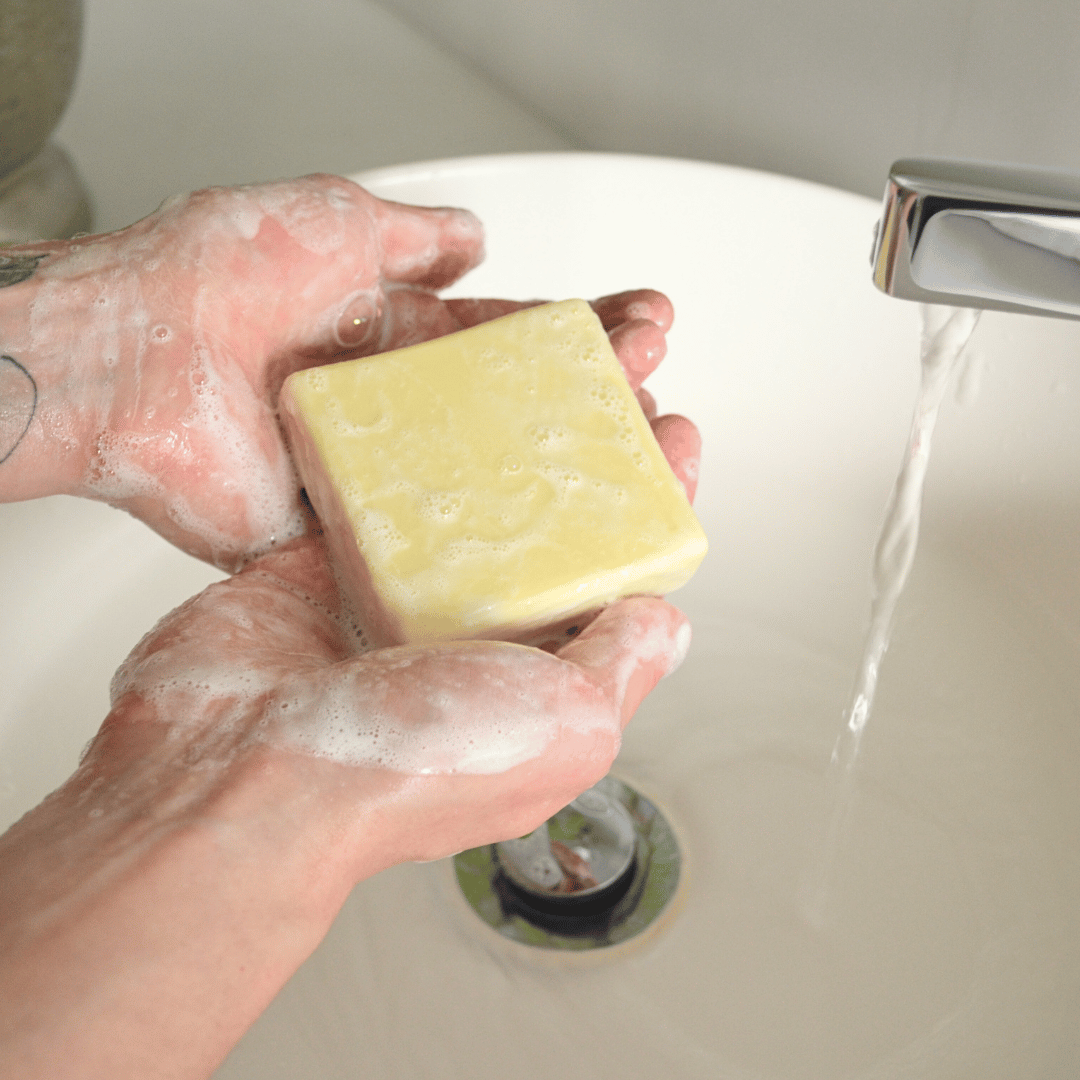 Olivskin Lemon & Orange Soap Block lathering in hands under running water