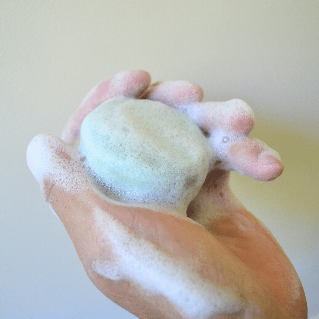 Olivskin Shampoo Block creating a rich foaming lather in hands